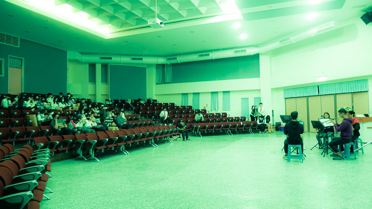 Students performing on stage in an auditorium in front of an audience