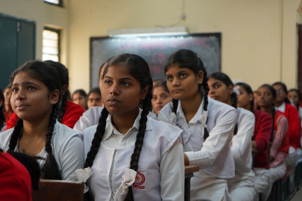Group of Indian schoolgirls in uniform listening attentively in class