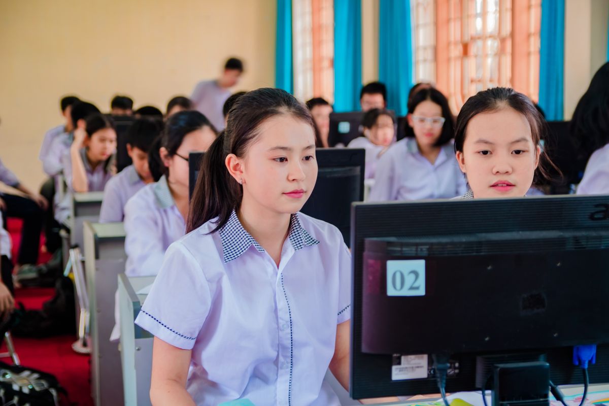 High-school students learning at workstations in a computer lab