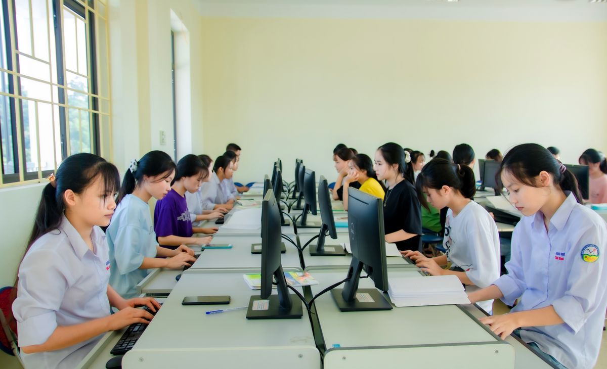 Students focused on desktop computers during a class in a computer lab
