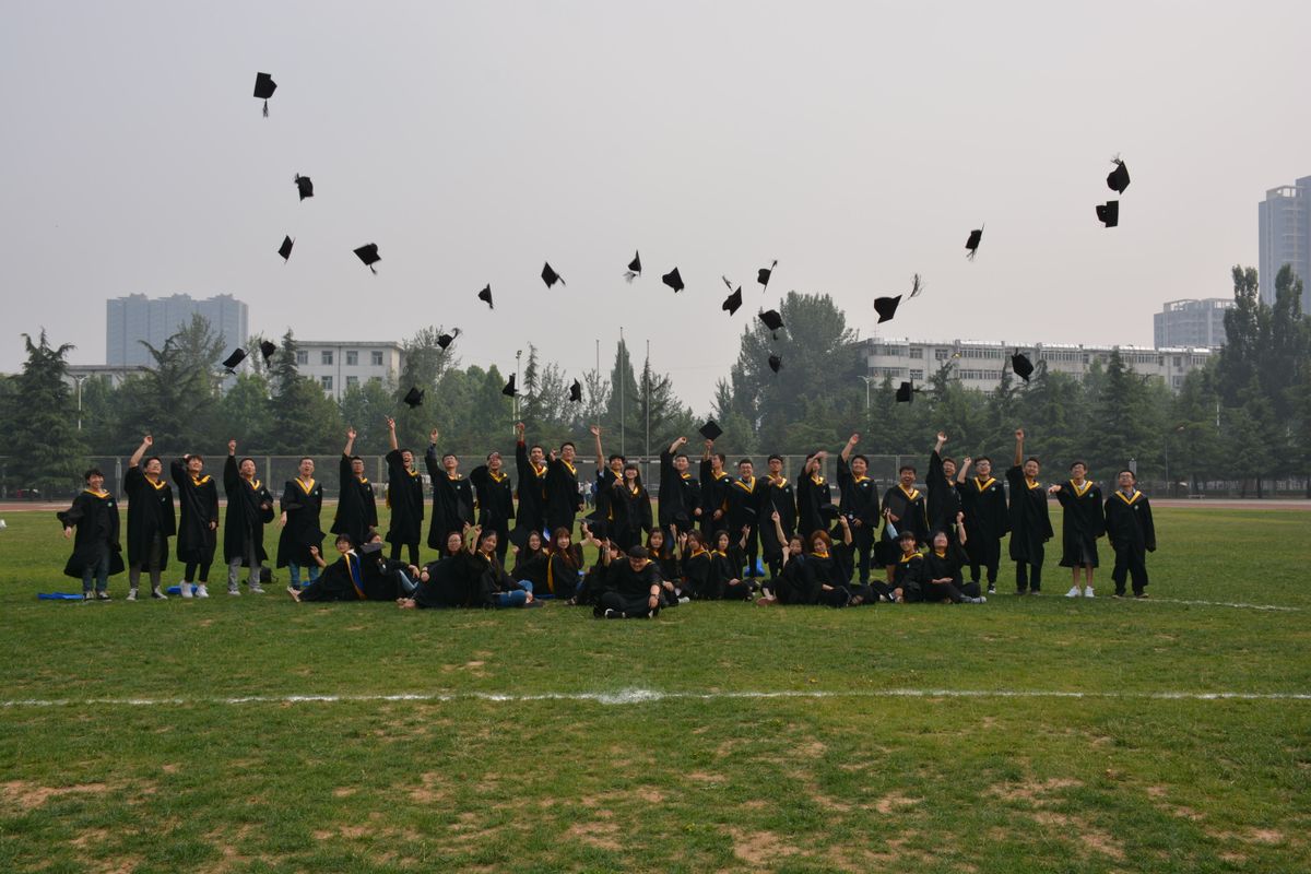 Large group of graduates tossing their caps in the air outdoors