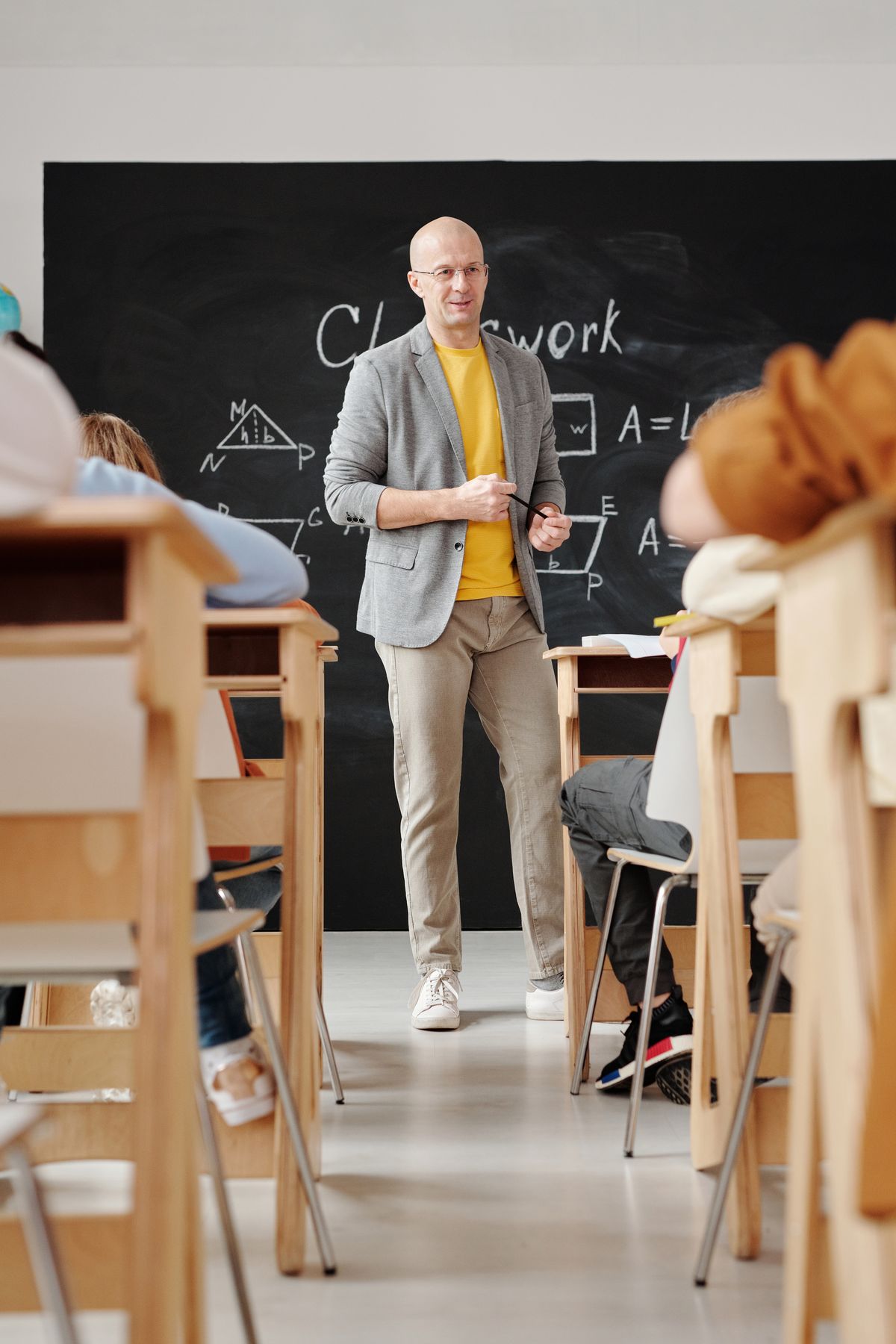 Teacher explaining geometry on a blackboard to attentive students